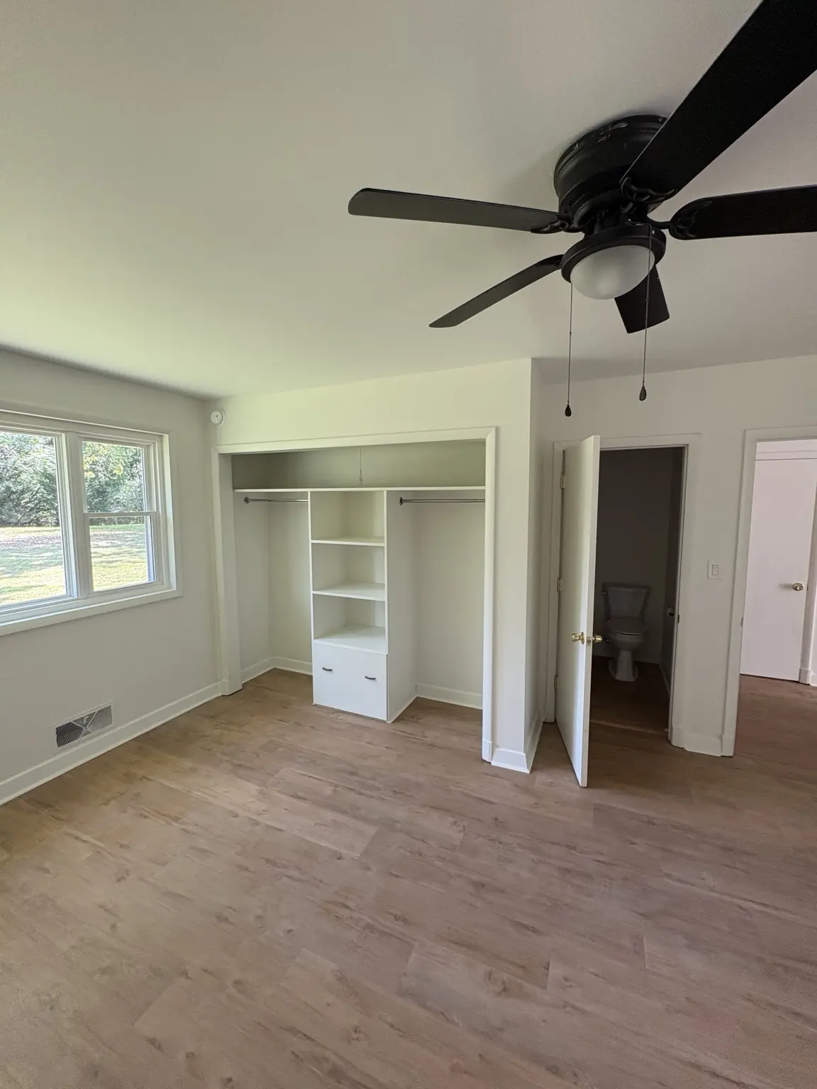 Completed Alabaster satin bedroom repaint with built-in shelving and doorway trim