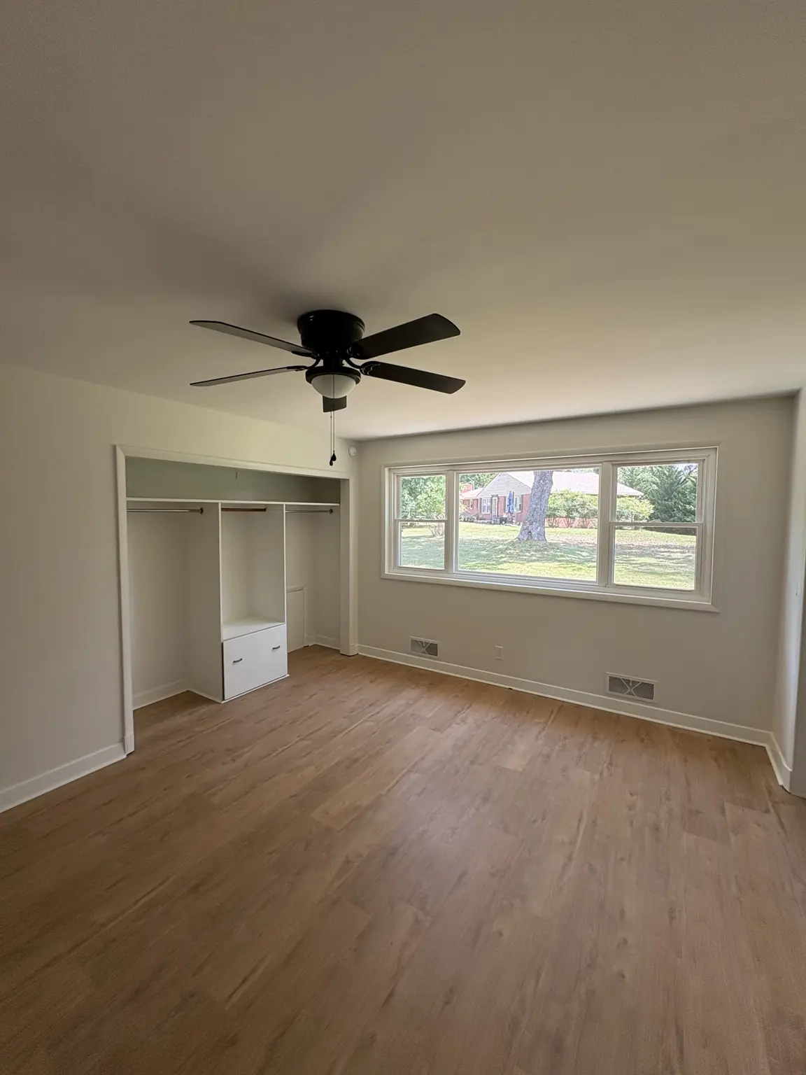 Completed Alabaster satin repaint in a bedroom with built-in shelving and large window